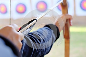 Archer holds his bow aiming at a target