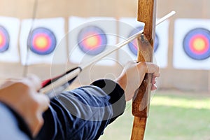 Archer holds his bow aiming at a target