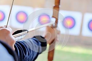 Archer holds his bow aiming at a target