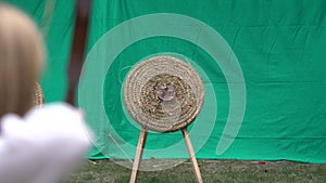 Archer holds his bow and shoots arrow at target. Archery competition, people aiming at center of the target to win the prize. Outd