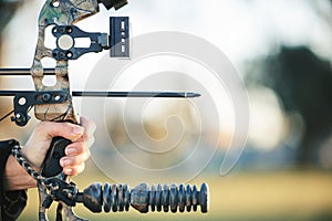 Archery bow and closeup of person at shooting range for competition, game or learning in field or outdoor sports. Woman