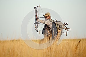 Archery hunter with his bow drawn back ready for a shot photo