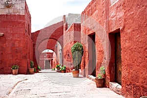 Arches in the courtyard in the monastery of Santa Catalina, Arequipa, Peru, large cacti and potted geraniums.