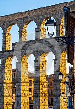 The arches of the Segovia aqueduct illuminated by the evening sunlight.