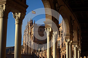 The arches of the stupendous Plaza De Espana, Spain and the spanish flag