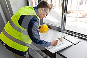 architect with blueprint and clipboard at office