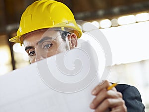 Architect with blueprint in construction site