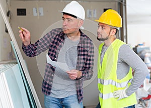 Architect and builder checking documentation in construction site