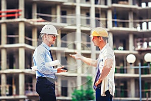 Architect and builder discussing at construction site