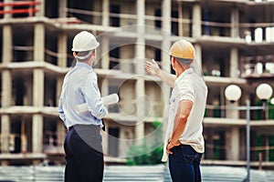 Architect and builder discussing at construction site