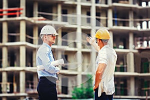 Architect and builder discussing at construction site