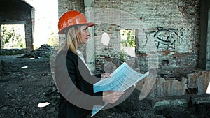 Architect builder engineer builder of ruined building looking girl work plan for the construction site construction plan