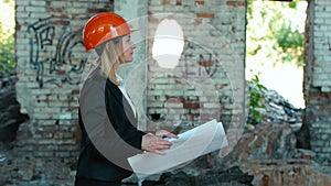 Architect builder engineer builder of ruined building looking girl work plan for the construction site construction plan