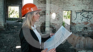 Architect builder engineer builder of ruined building looking girl work plan for the construction site construction plan