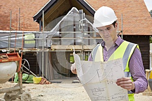 Architect On Building Site Looking At House Plans photo