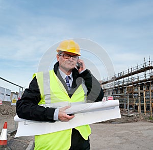 Architect on building site phoning