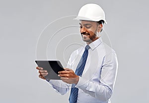 Architect or businessman in helmet with tablet pc