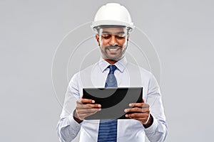 Architect or businessman in helmet with tablet pc