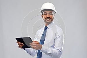 Architect or businessman in helmet with tablet pc