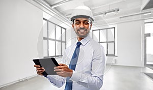 Architect or businessman in helmet with tablet pc