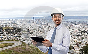 Architect or businessman in helmet with tablet pc