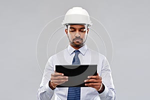 Architect or businessman in helmet with tablet pc