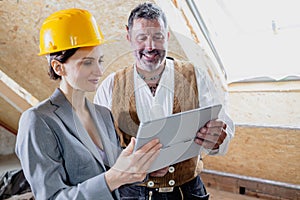 architect and carpenter on construction site with tablet computer