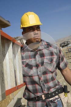 Architect Carrying Stepladder At Site photo