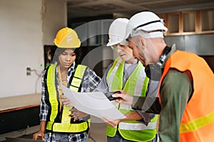 Architect caucasian man and woman working with colleagues mixed race in the construction site. Architecture engineering on big