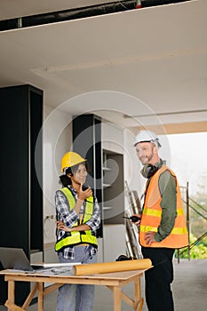 Architect caucasian man and woman working with colleagues mixed race in the construction site. Architecture engineering on big