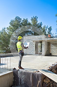 Architect checking the plans of a house under construction