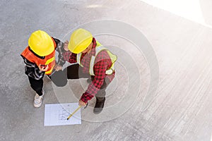 Architect and client discuss help create plan with blueprint of the building at construction site floor