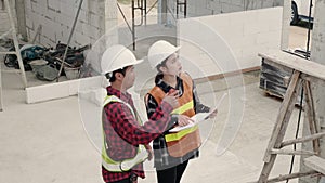 Architect and client discussing the plan with blueprint of the building at construction site. Asian engineer foreman worker man an
