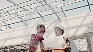 Architect and client discussing the plan with blueprint of the building at construction site. Asian engineer foreman worker man an