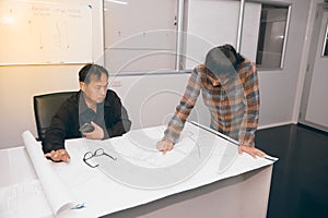 Architect and construction engineer discussing plan in office.
