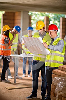 Architect and construction worker look blue print