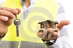Architect or constructor hands holding keys and house model