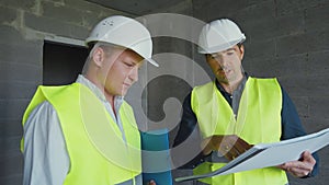 Architect and contractor discussing plans on construction site