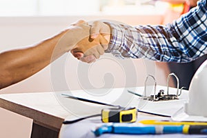 Architect contractor shaking hands with client.