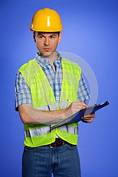 Architect in coveralls and hardhat using clipboard