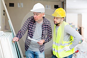 Architect discussing work with builder in construction site
