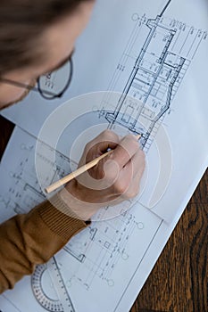 Architect drawing blueprint sketching design of house, making architectural construction building.