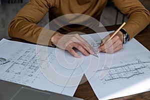 Architect drawing blueprint sketching design of house, making architectural construction building.