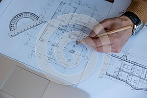 Architect drawing blueprint sketching design of house, making architectural construction building.