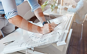 Architect drawing a plan for a building project inside his office. Closeup of a male engineer doing a blueprint sketch