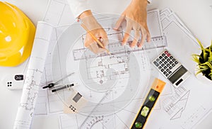 Architect drawing with ruler on house plan blueprint paper for repair tools on table