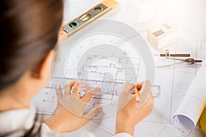 Architect drawing with ruler on house plan blueprint paper for repair tools on table