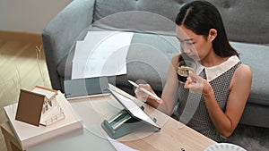 Architect drinking coffee and working online with computer tablet at home.