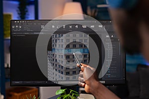 Architect engineer pointing at architectural building prototype