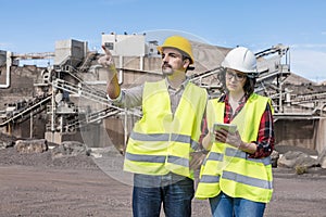 Architect and engineer with tablet examining construction site photo